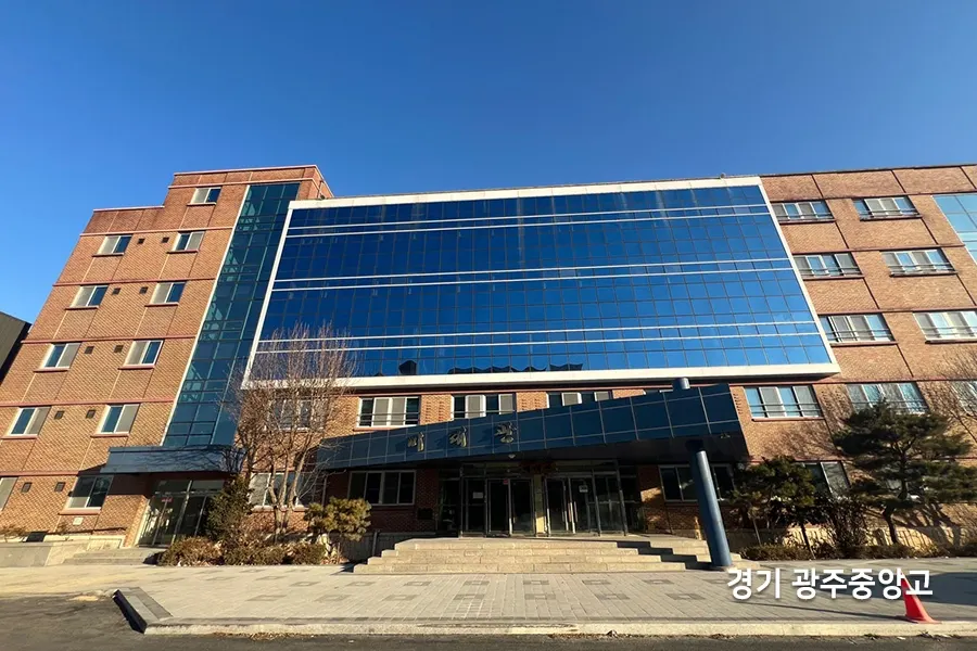 계단식 관람석 위로 넓게 뚫린 통유리창에 짙은 톤의 열차단 필름이 시공된 강당 내부 전경