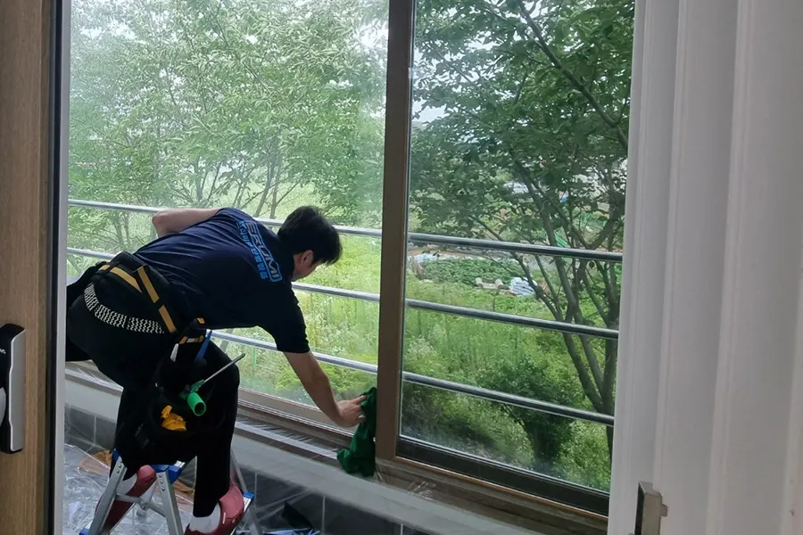 천장 조명 아래 이어진 통유리 창틀 구간을 순서대로 마감한 다목적홀 내부