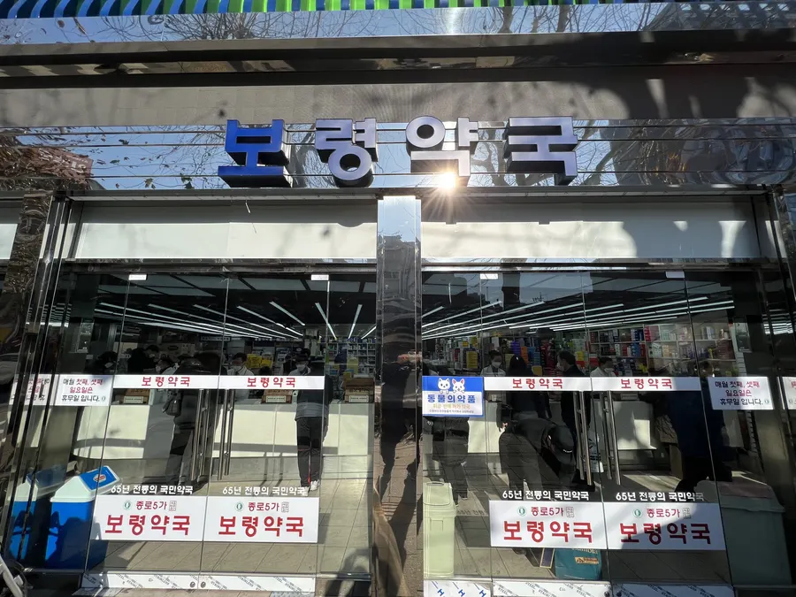 시공을 마친 통유리 출입문 너머로 거리와 간판이 비치는 전경